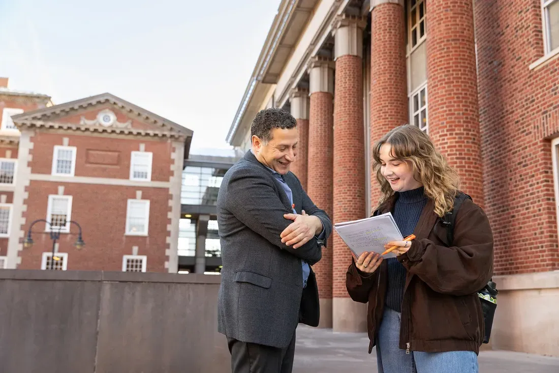 Student Megan Edenfeld talking to a professor outside.